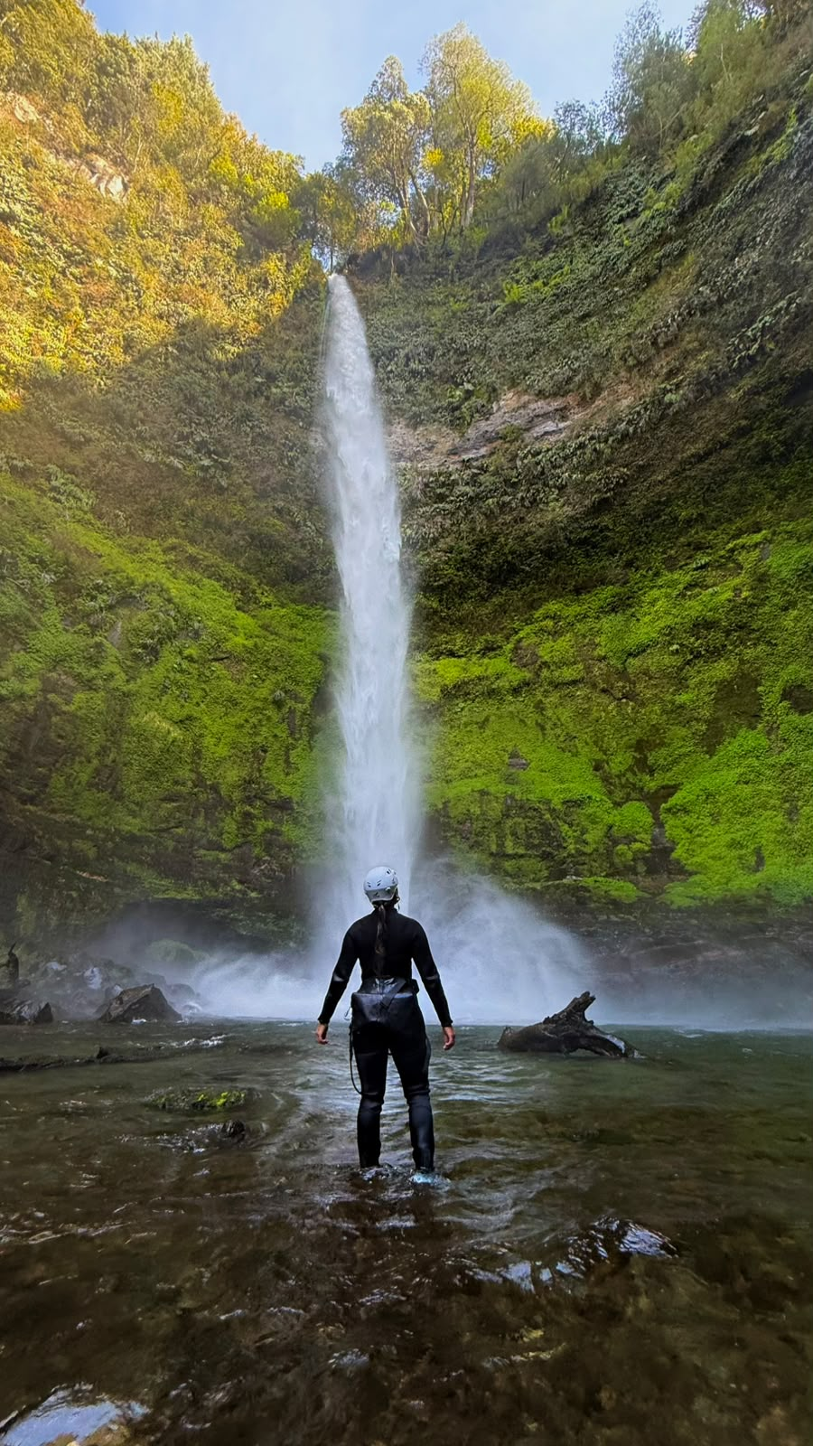 Participante de pie en el pozón contemplando la caída completa del Salto El Claro