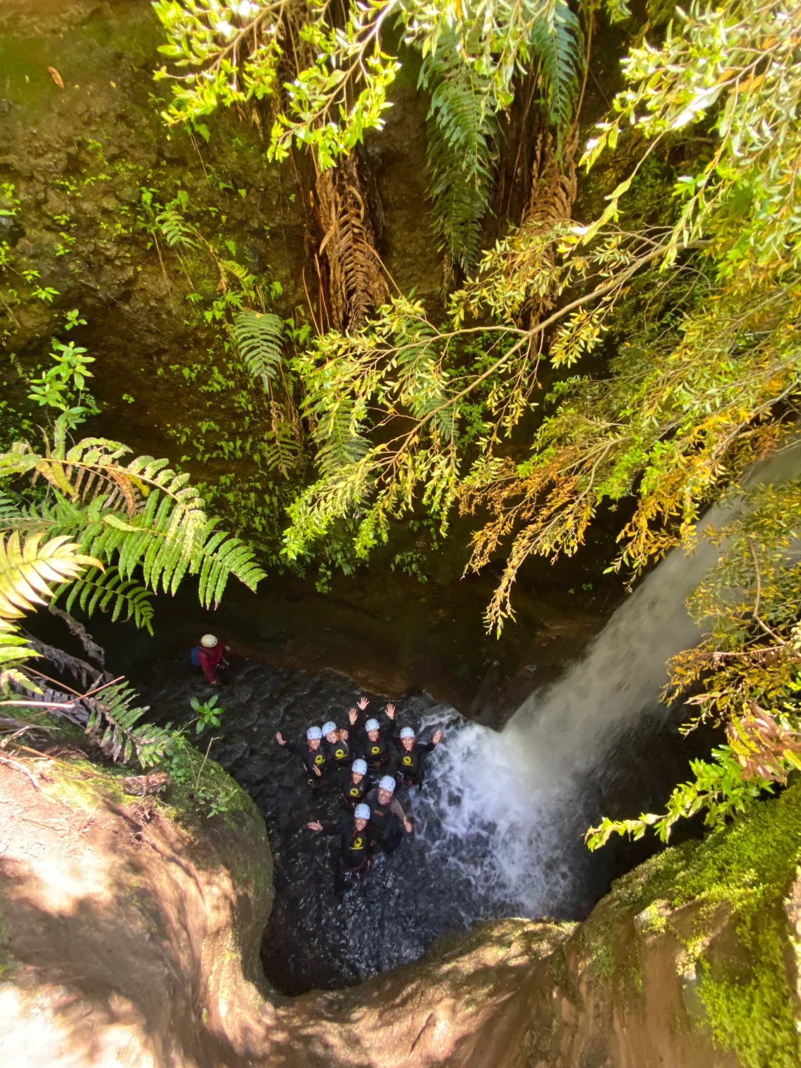 Grupo de canyoning celebrando en el pozón al pie de una cascada del Salto El Claro, Pucón