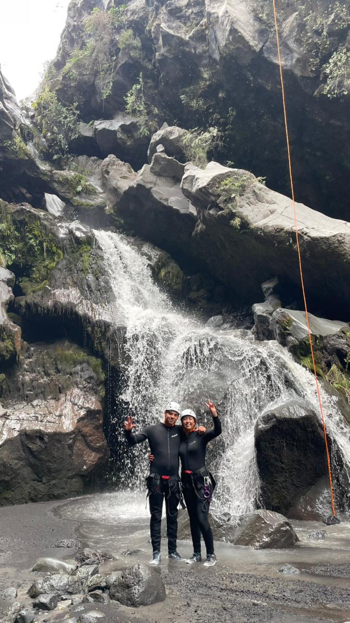 Dos participantes celebrando frente a la cascada del cañón El Pillán